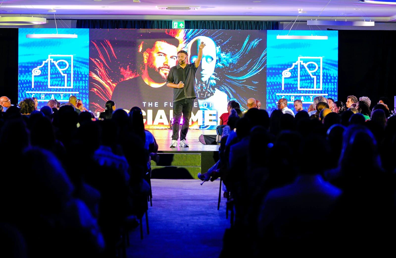 Speaker presenting on stage to a tech conference audience