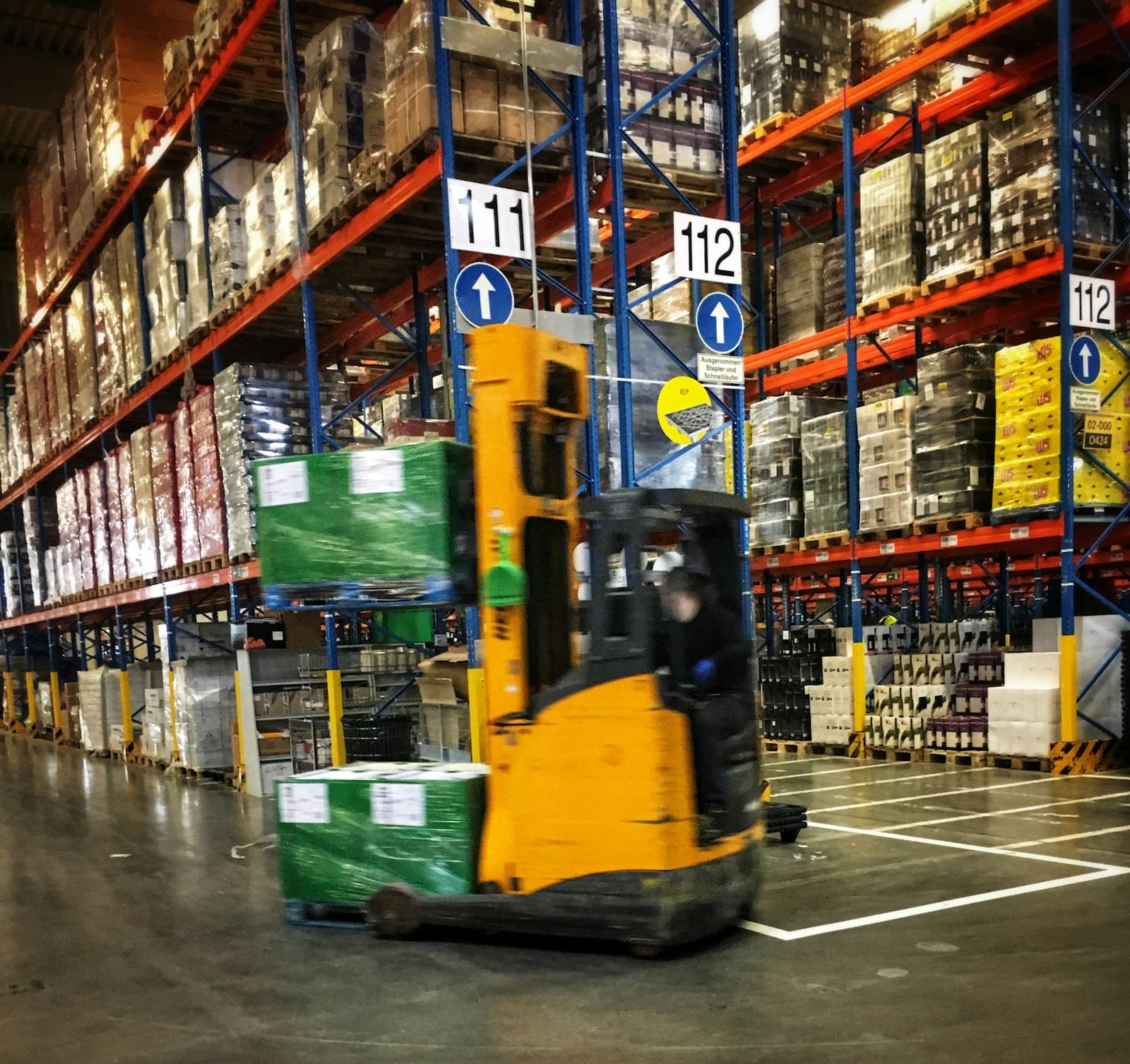 Forklift moving pallets inside a logistics warehouse